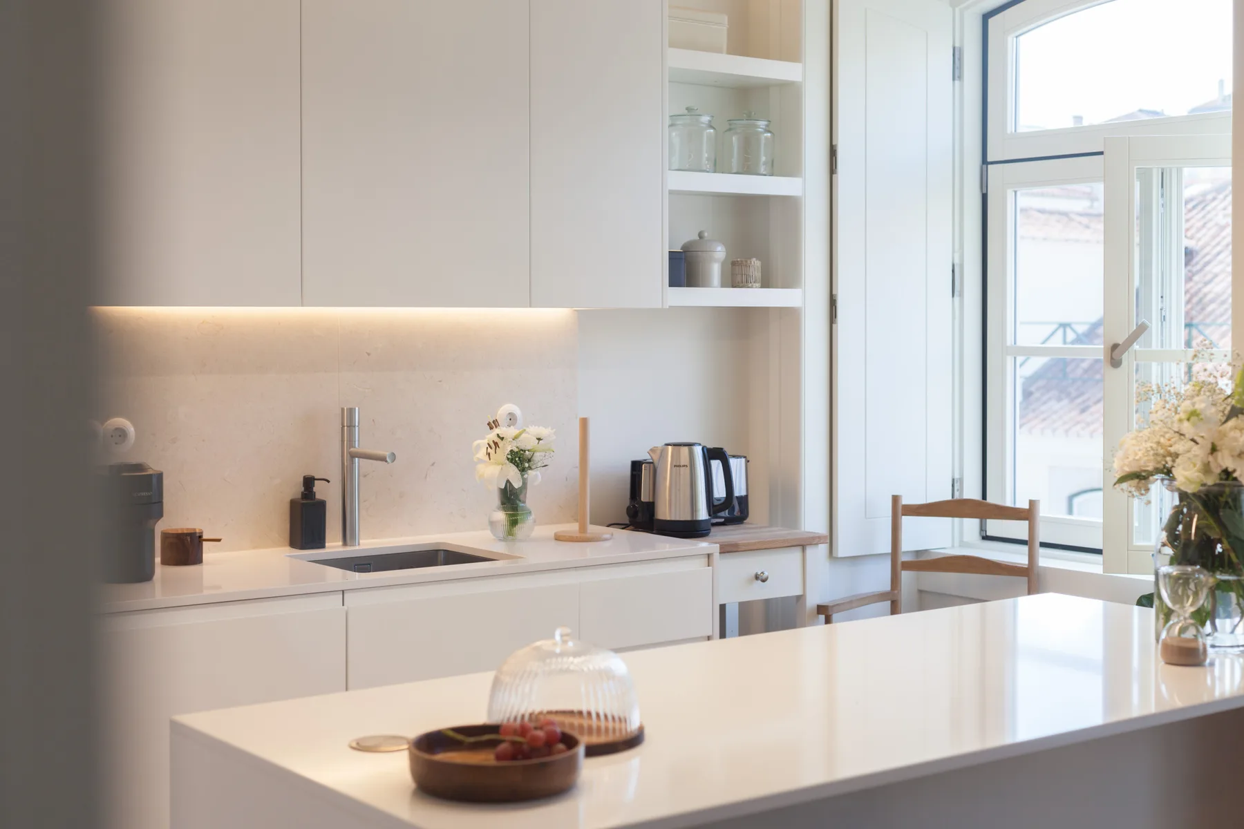 A bright kitchen with a white island and large windows.