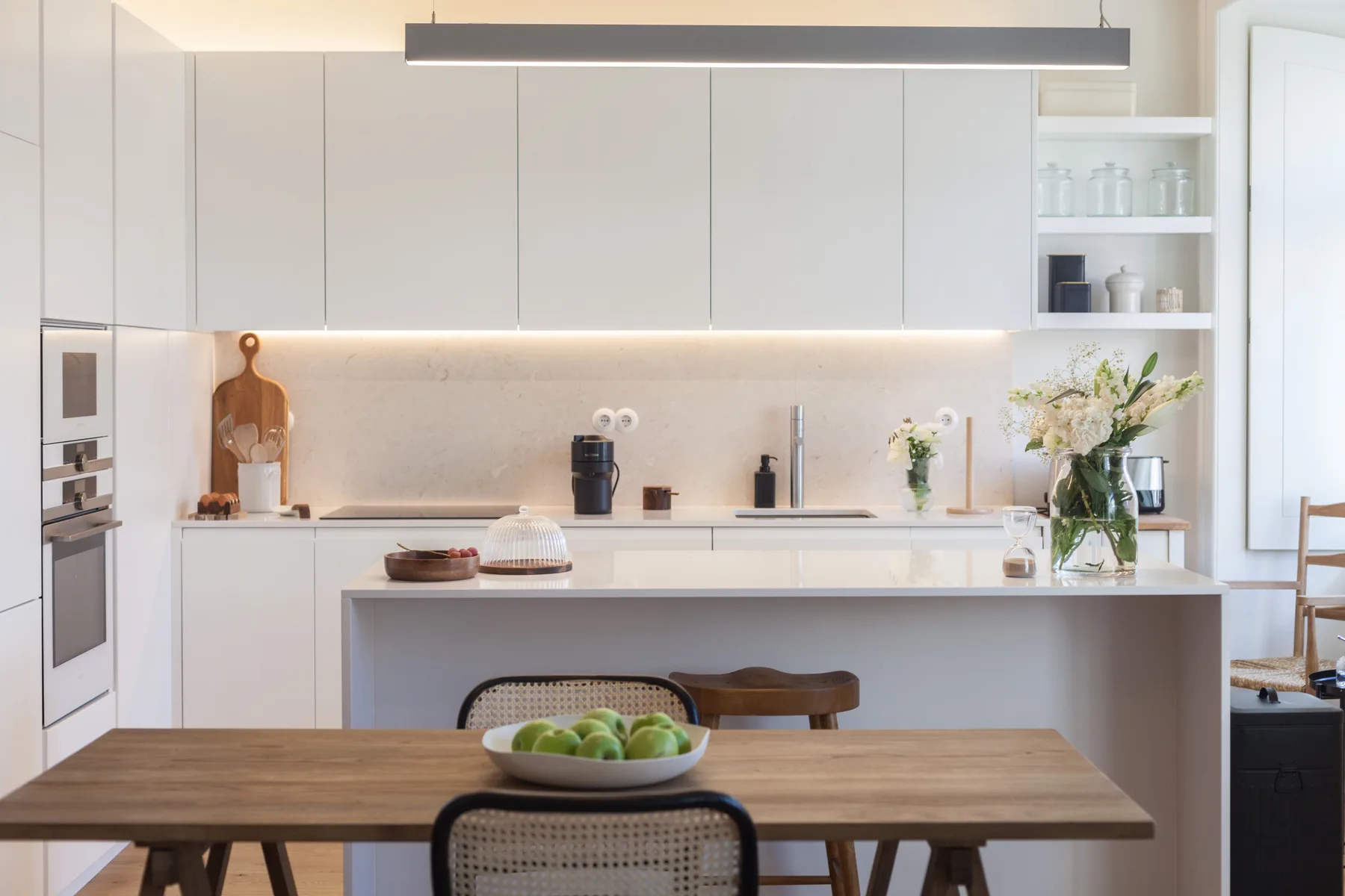A bright modern kitchen with a dining table and an island.