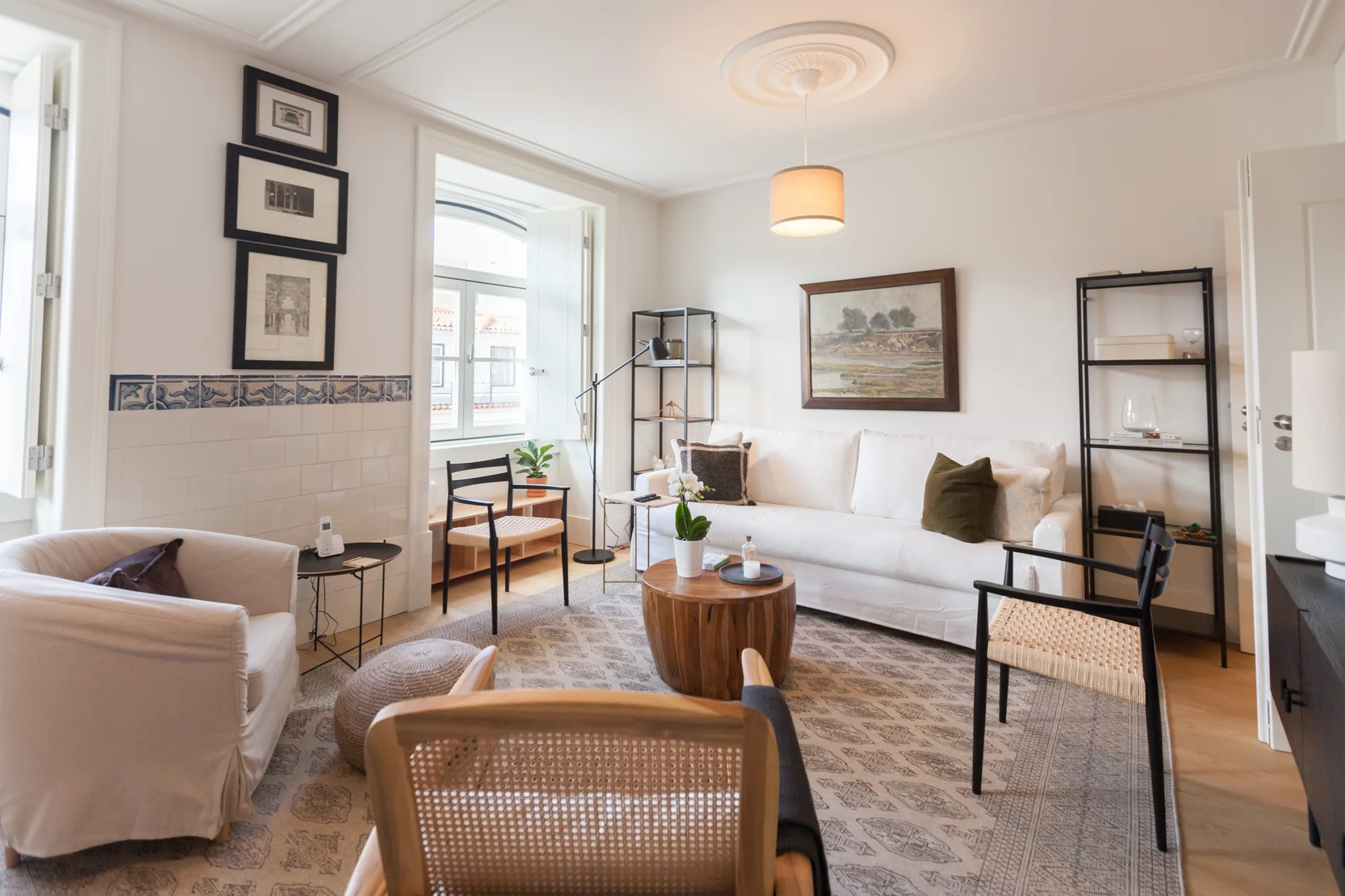 A bright living room with seating around a wooden coffee table and large windows.