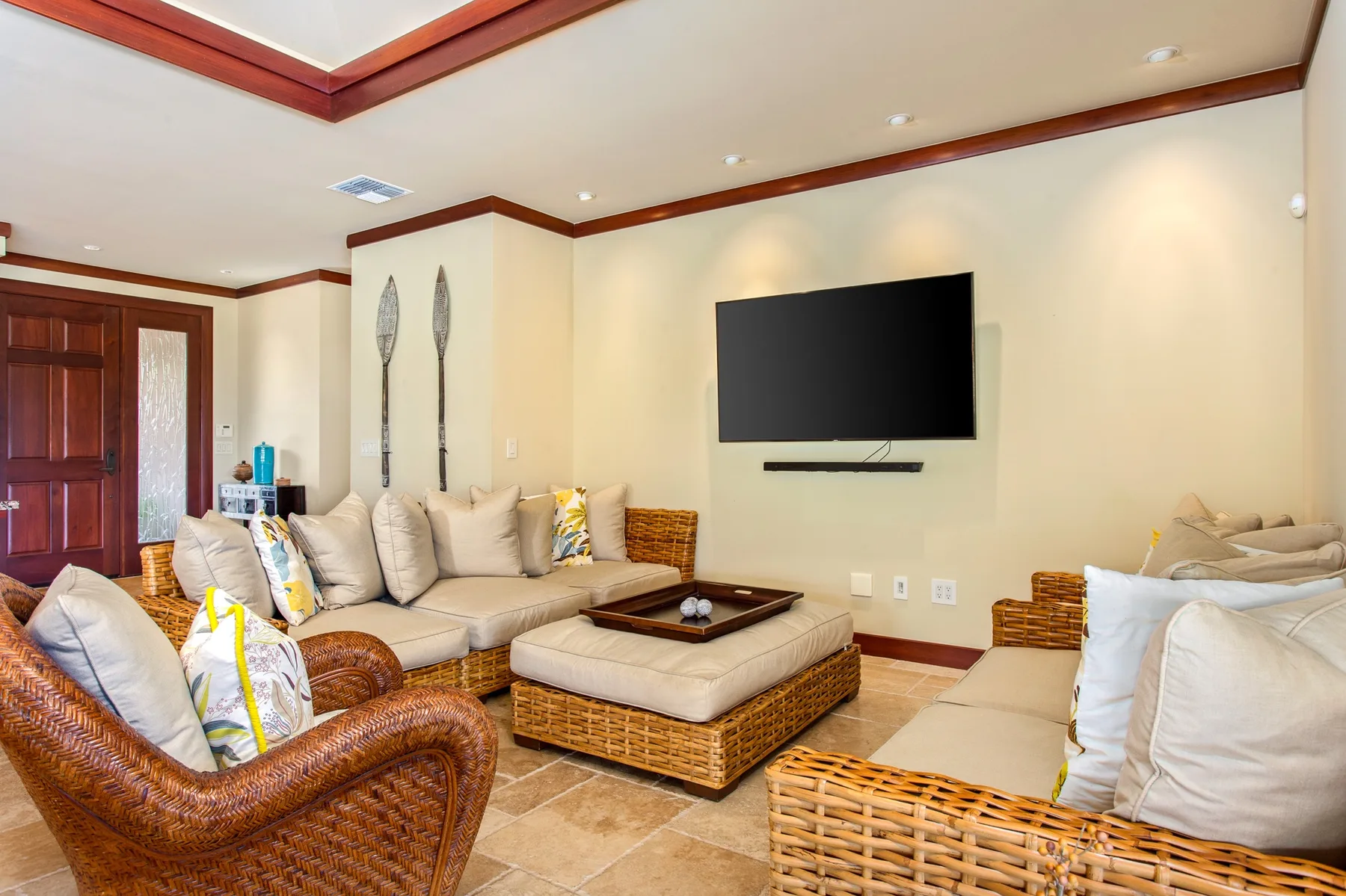 Una sala de estar con asientos acolchados, un televisor y una mesa baja central.
