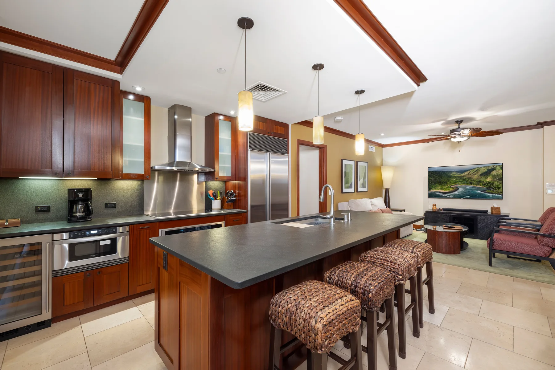 Una cocina abierta con sala de estar, una isla grande y asientos.