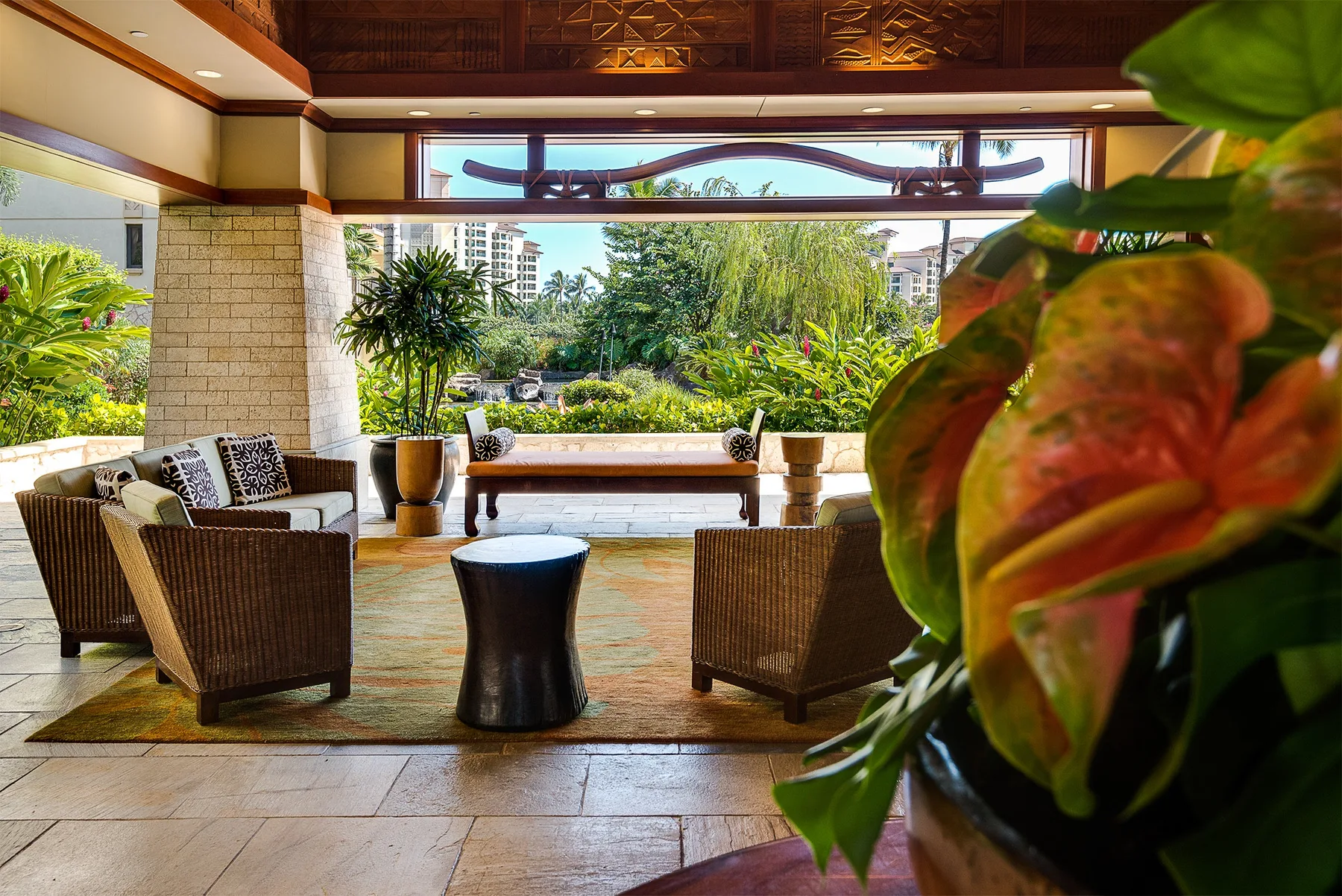 Una sala al aire libre con asientos y vistas a una frondosa vegetación.