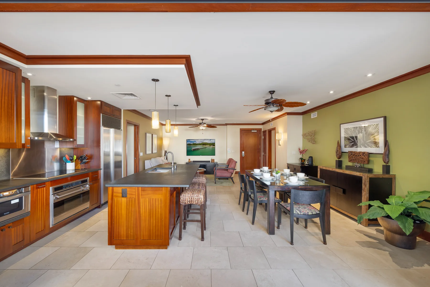 Cocina abierta y comedor con gabinetes de madera y una mesa puesta.