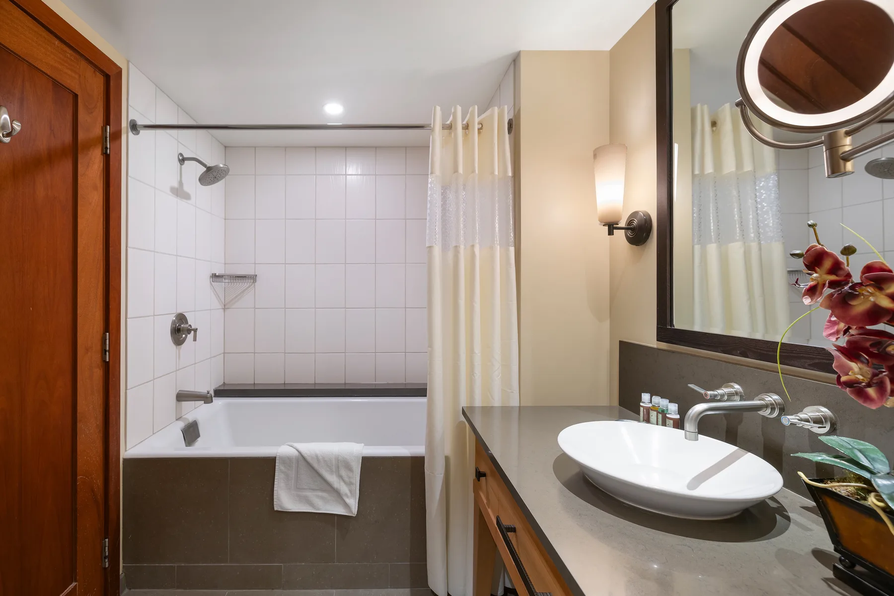 Un baño con bañera, cortina de ducha y lavabo.