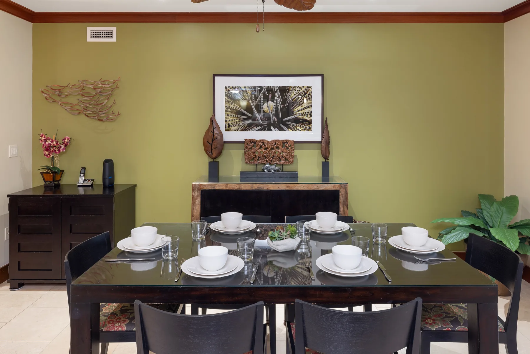 Un comedor con una mesa larga puesta con platos y tazas.