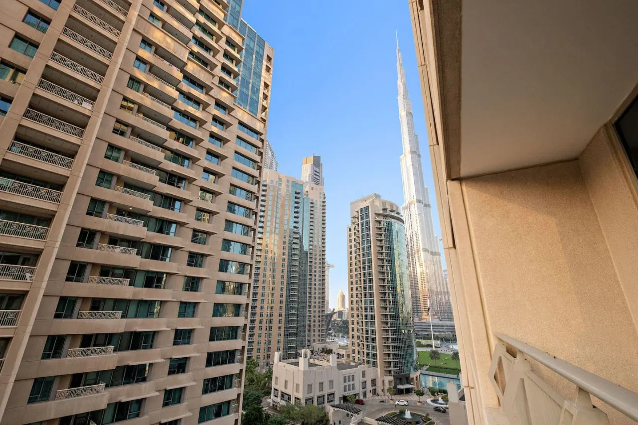 Vista urbana de edificios altos desde un balcón.