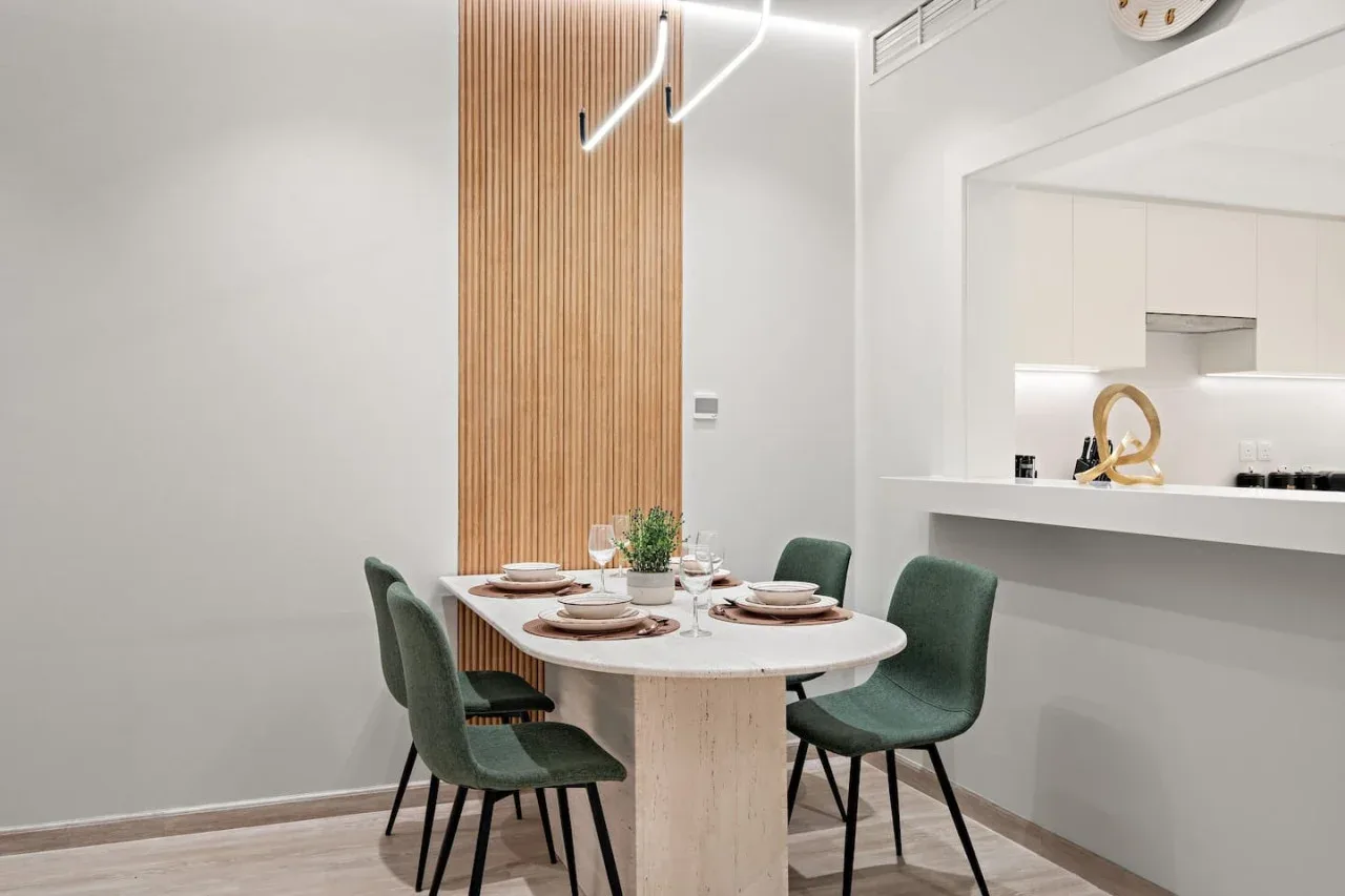 Comedor con la mesa puesta junto a una cocina abierta.