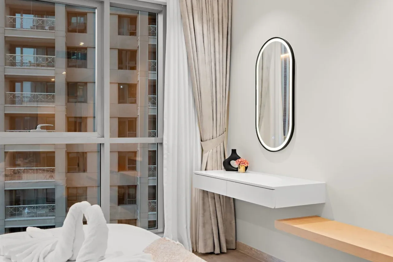 Dormitorio con una ventana grande y un tocador de pared.