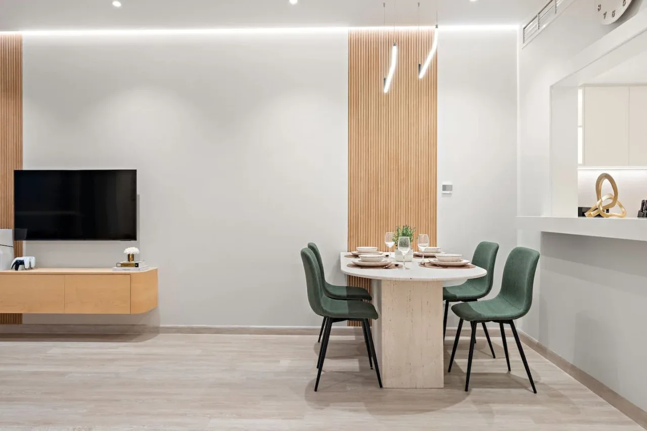 Comedor moderno con una mesa preparada y un televisor cerca.