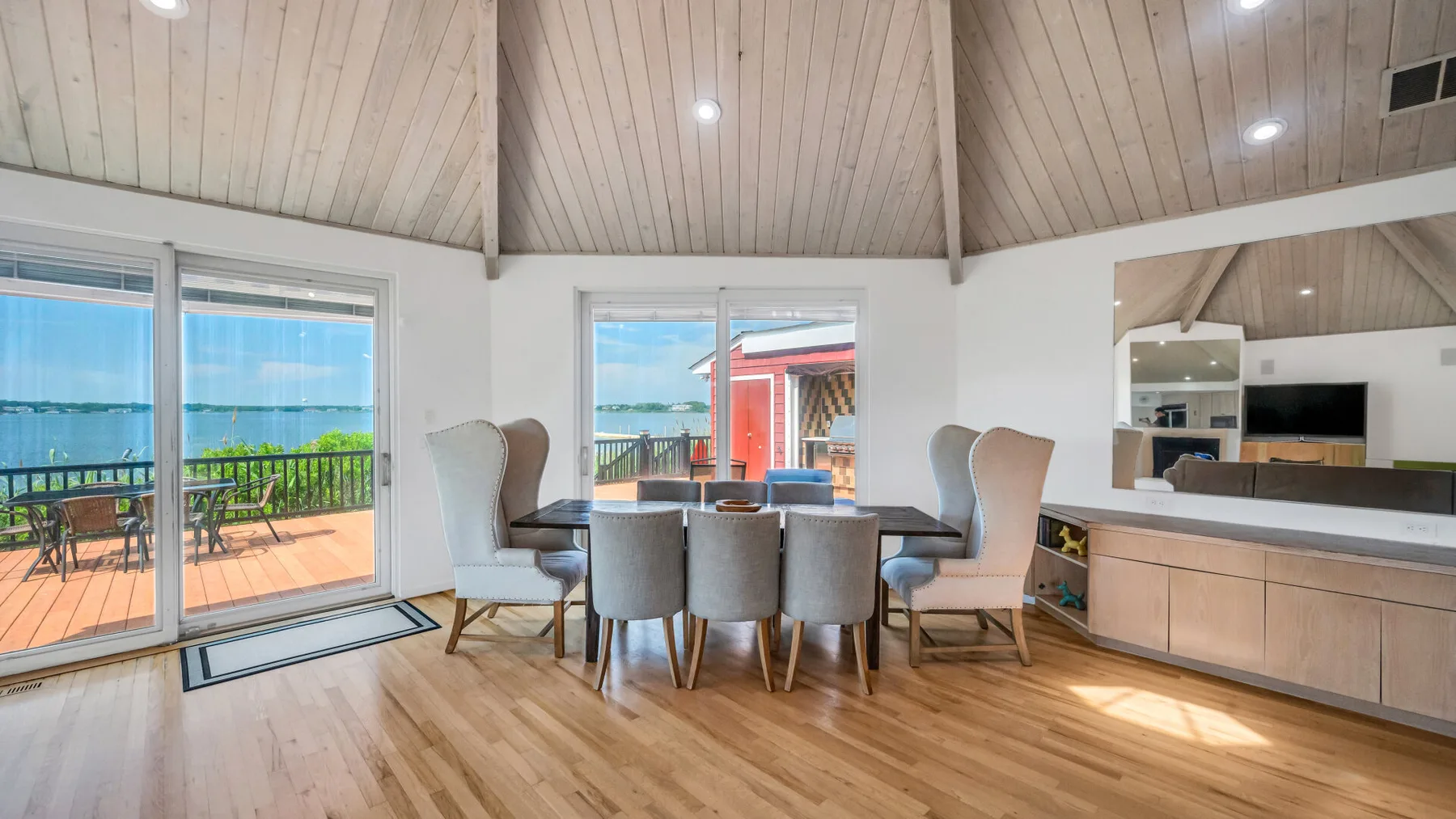Un comedor luminoso con una mesa y grandes ventanas con vistas a una terraza.
