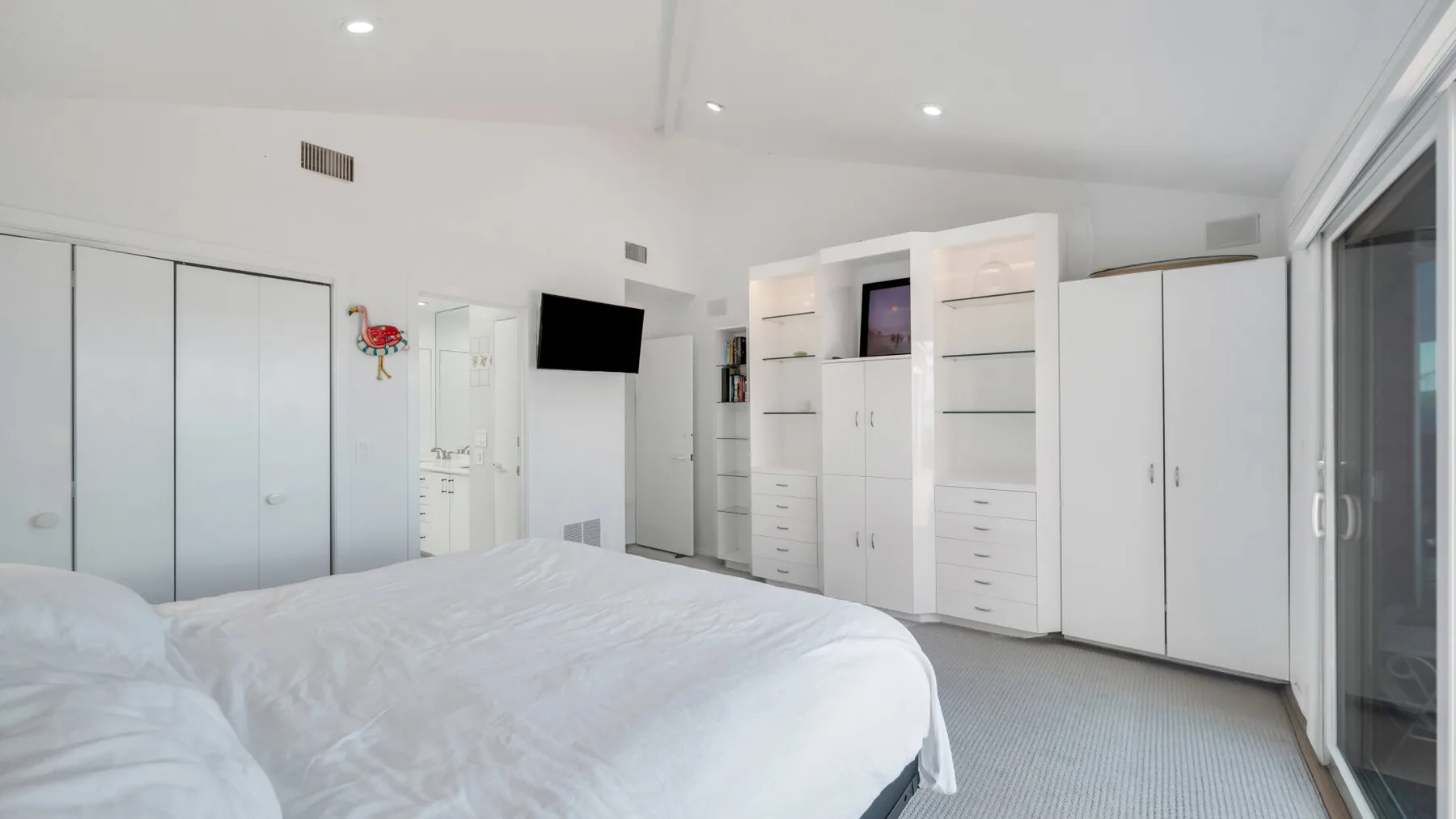 Un dormitorio luminoso con una cama grande y armarios empotrados.