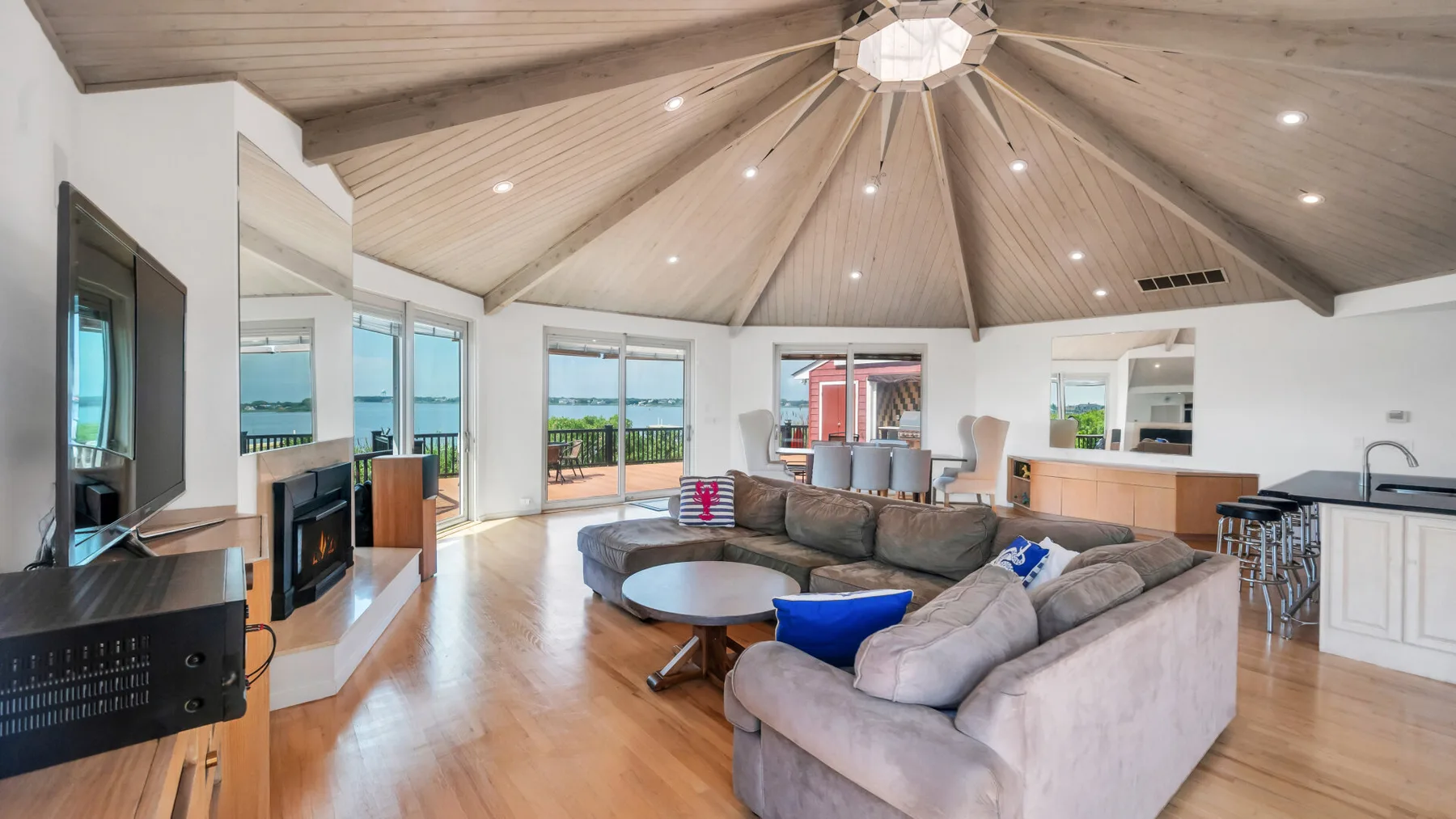 An open living room with a sectional seating area, dining space, and kitchen.