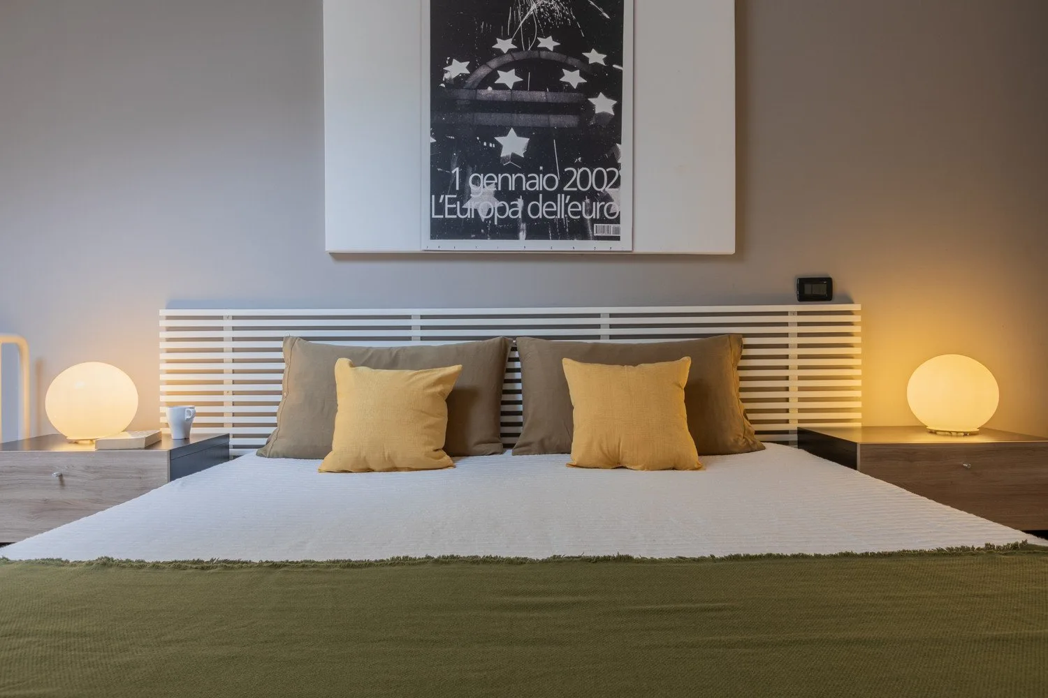 A bedroom with a neatly made bed and matching bedside lamps.