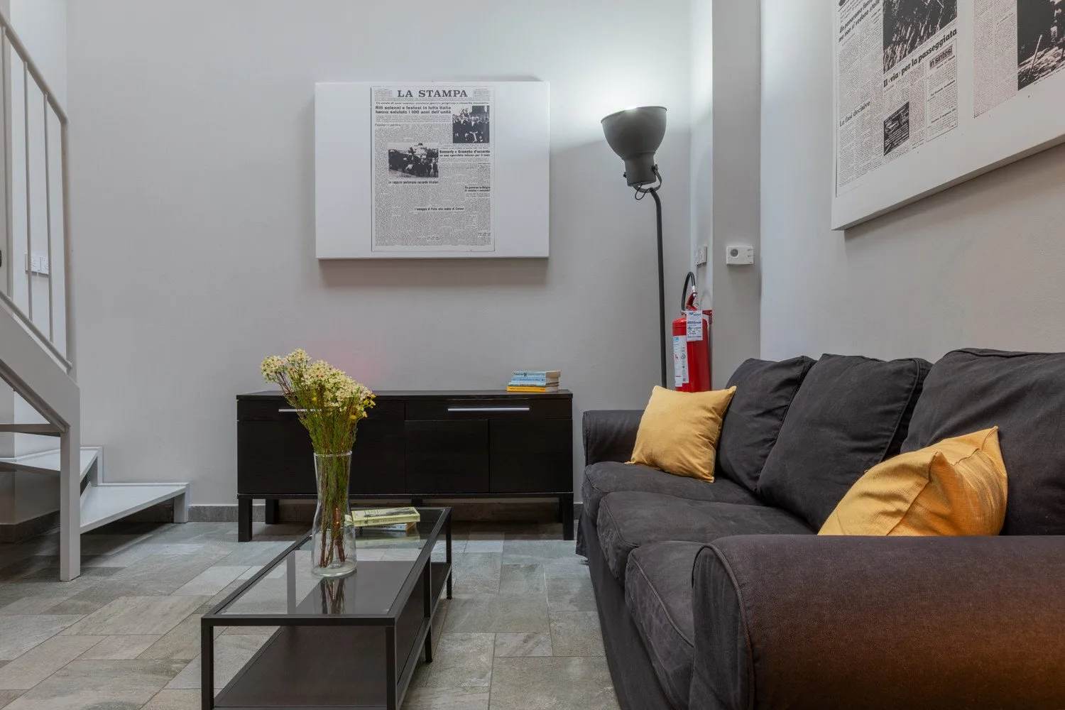A living room with dark seating, a coffee table, and wall art.
