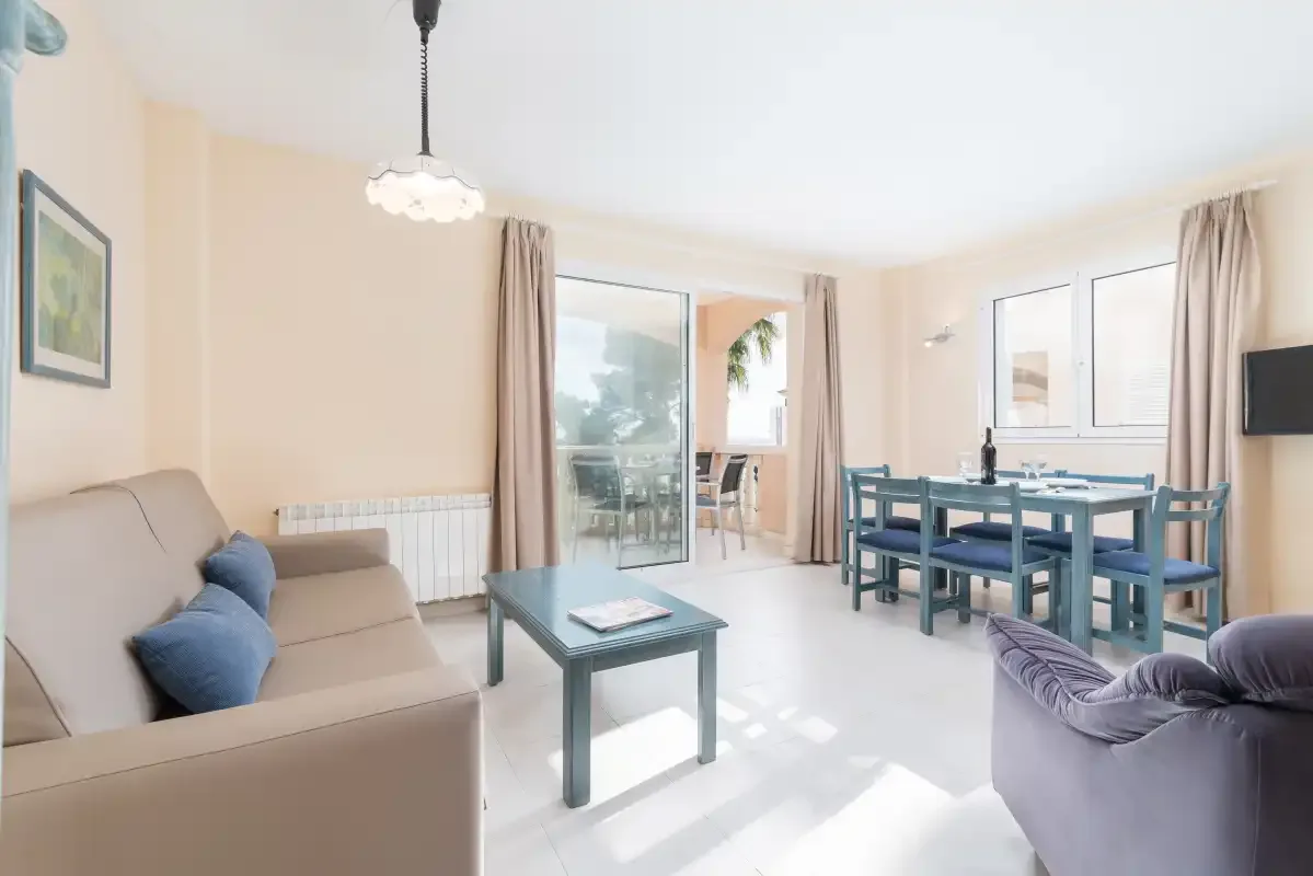 A bright living and dining area with a table beside the glass doors.
