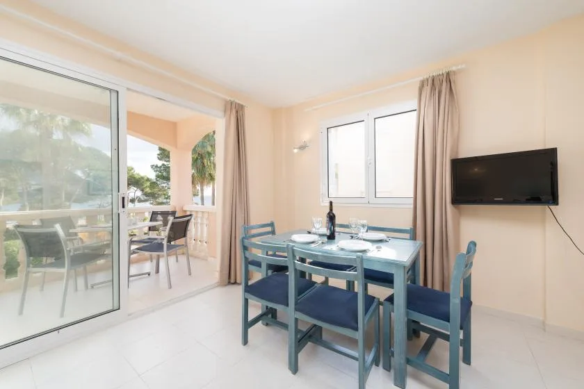 A dining area with a table and chairs beside sliding glass doors.