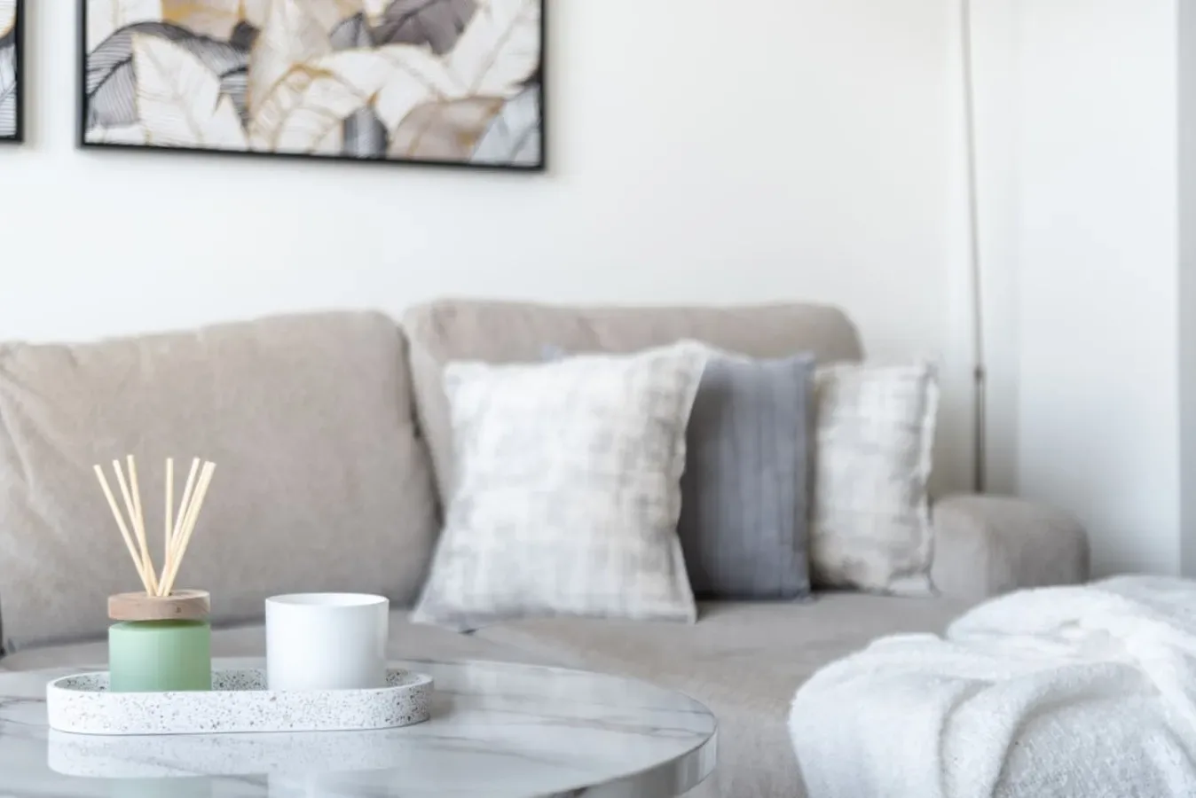 A living room seating area with neutral cushions and a coffee table.