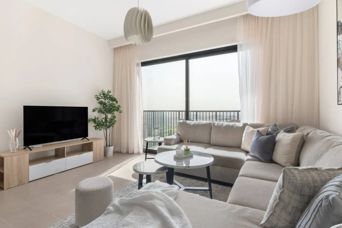 A bright living room with sectional seating, a coffee table, and large windows.