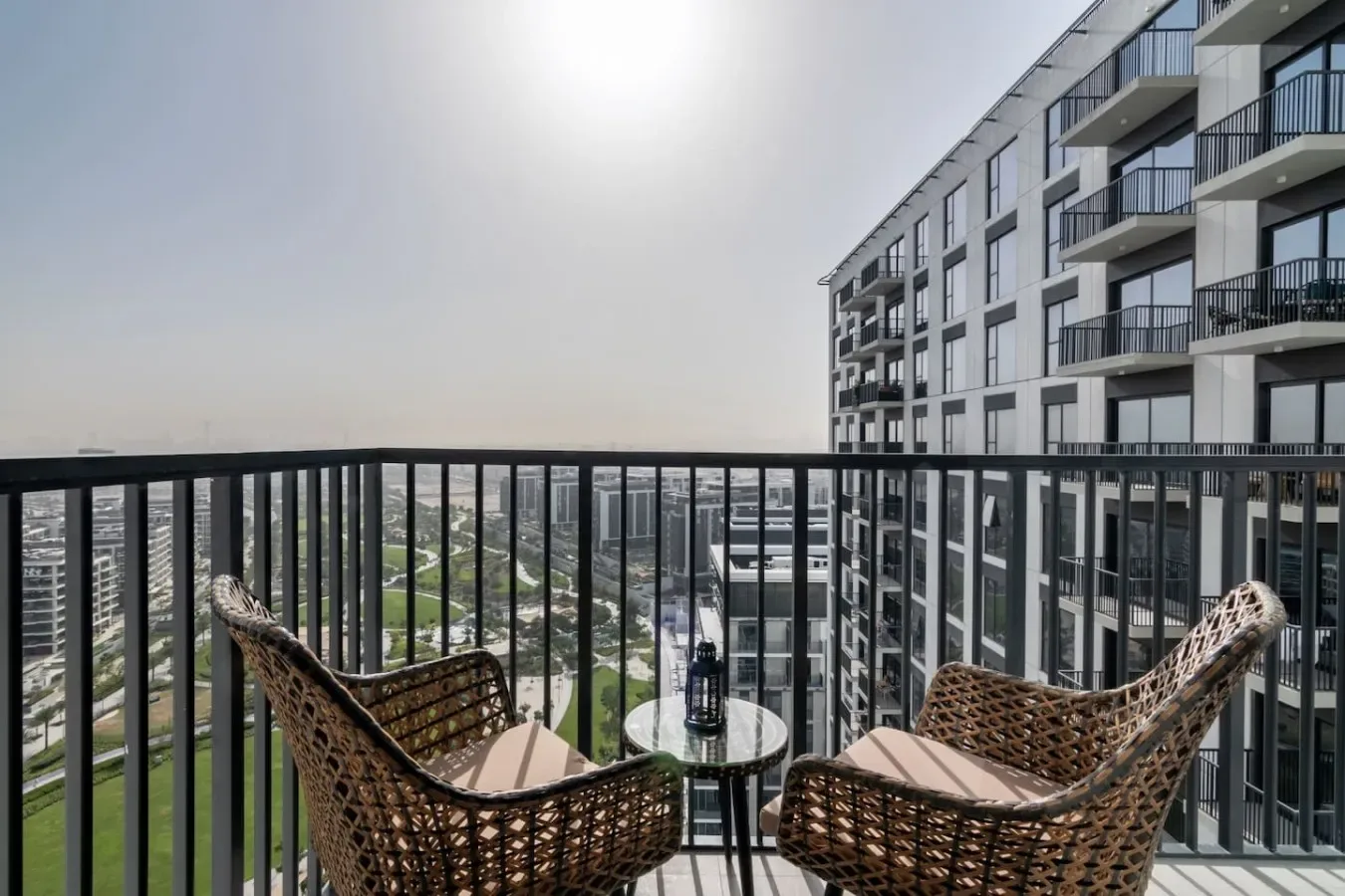 A balcony seating area overlooks nearby buildings and the city.