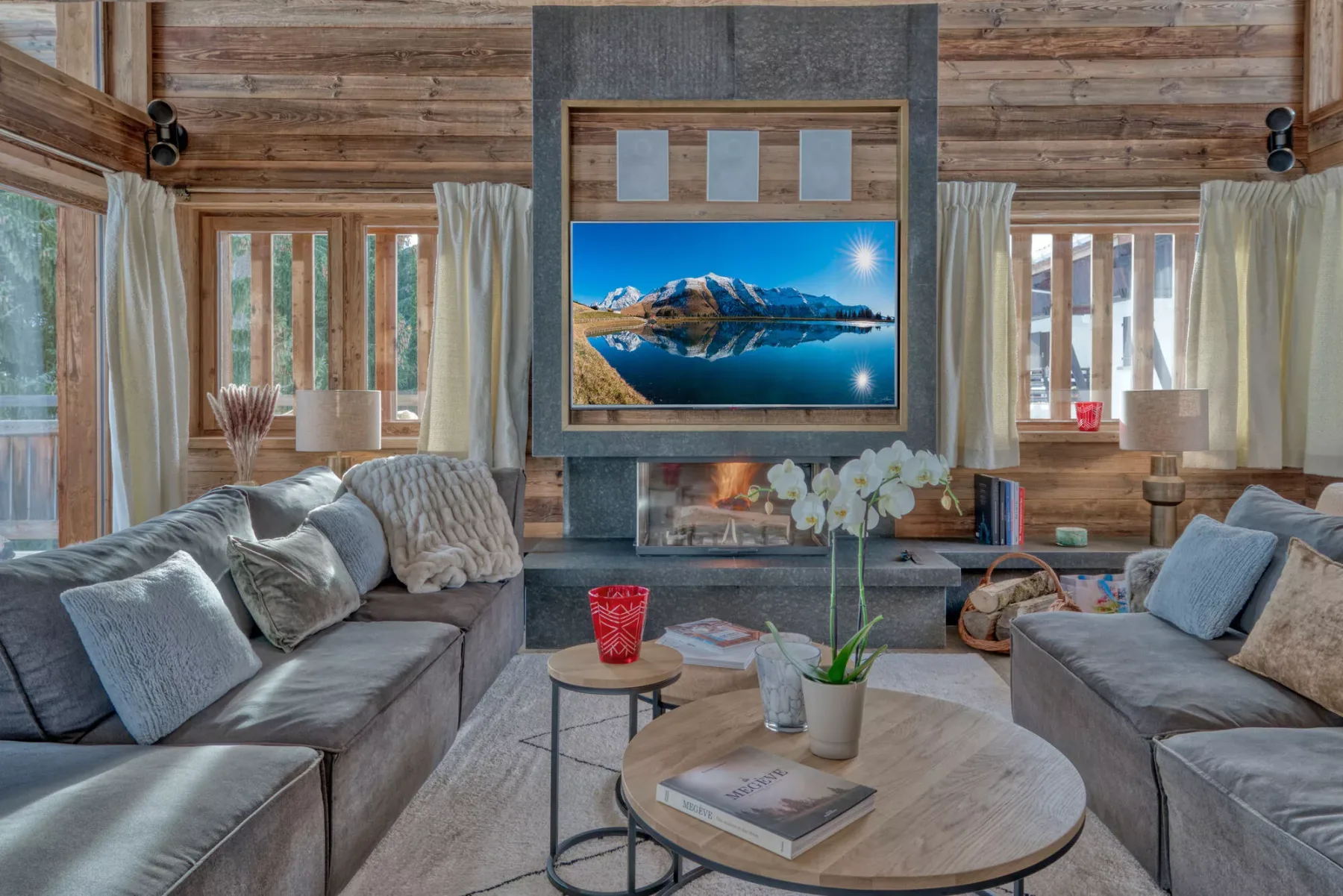 A wood-paneled living room with seating arranged around a fireplace and coffee table.