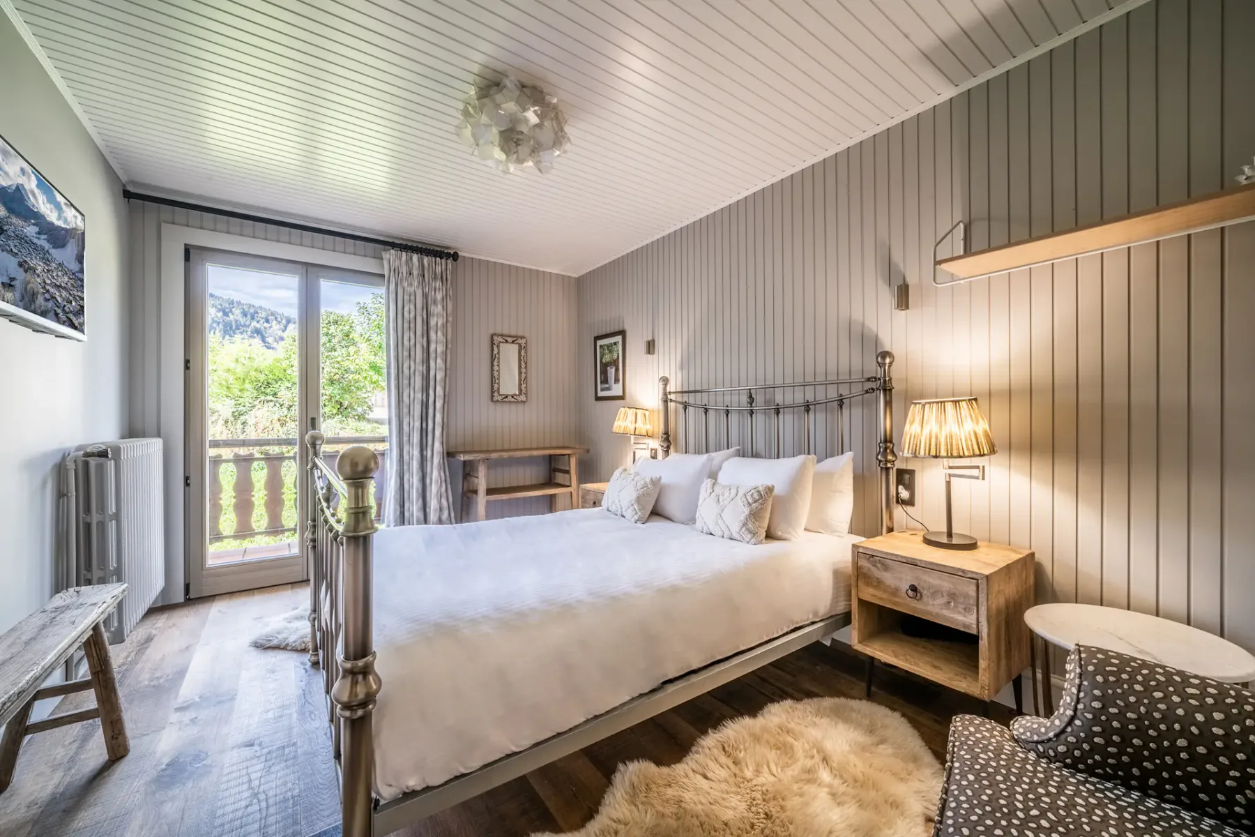 Un dormitorio con cama doble, mesillas de noche y una puerta al balcón.