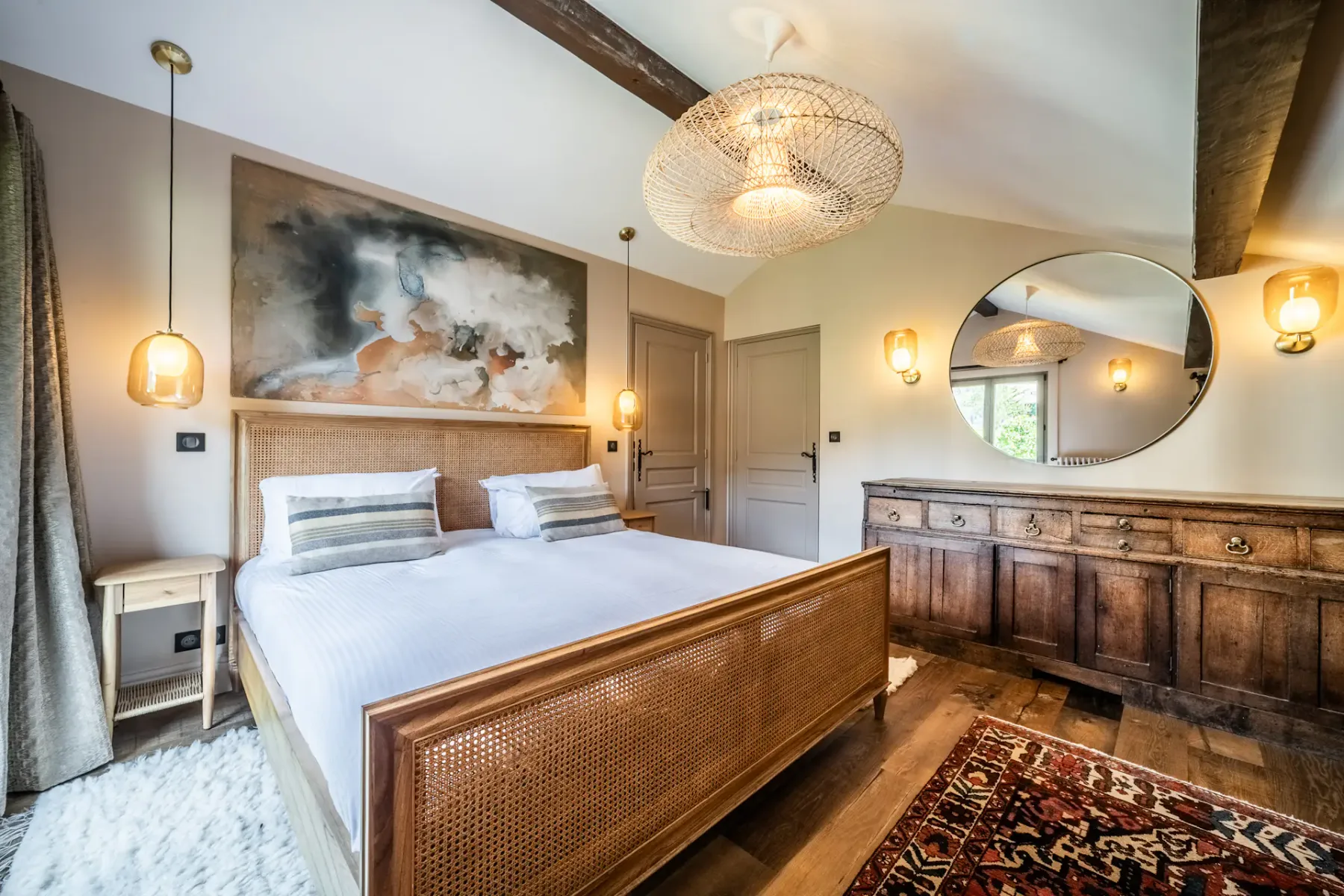 Un dormitorio con una cama, muebles de madera y un espejo grande.