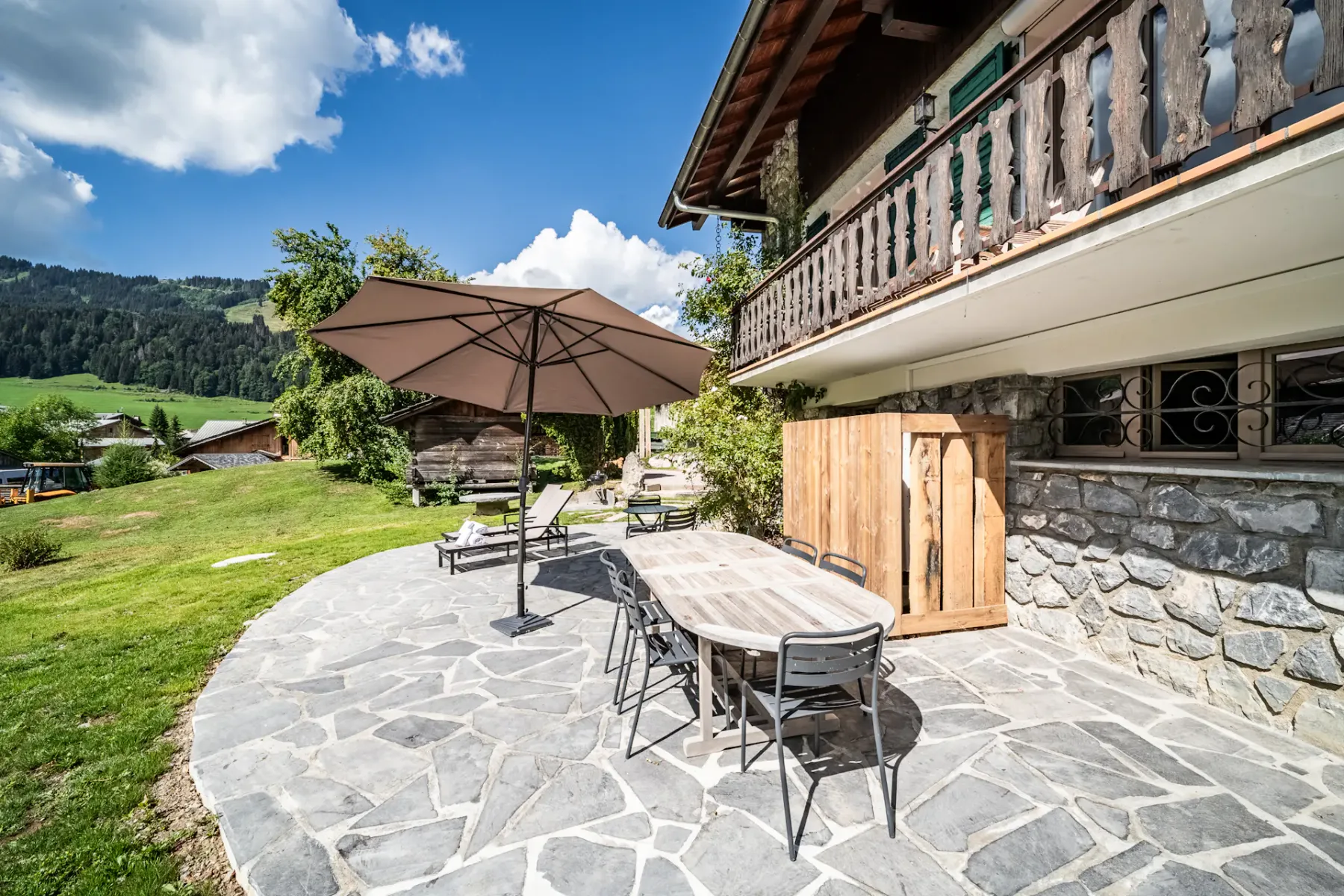 Un patio al aire libre con una mesa y sillas junto a un edificio rústico.