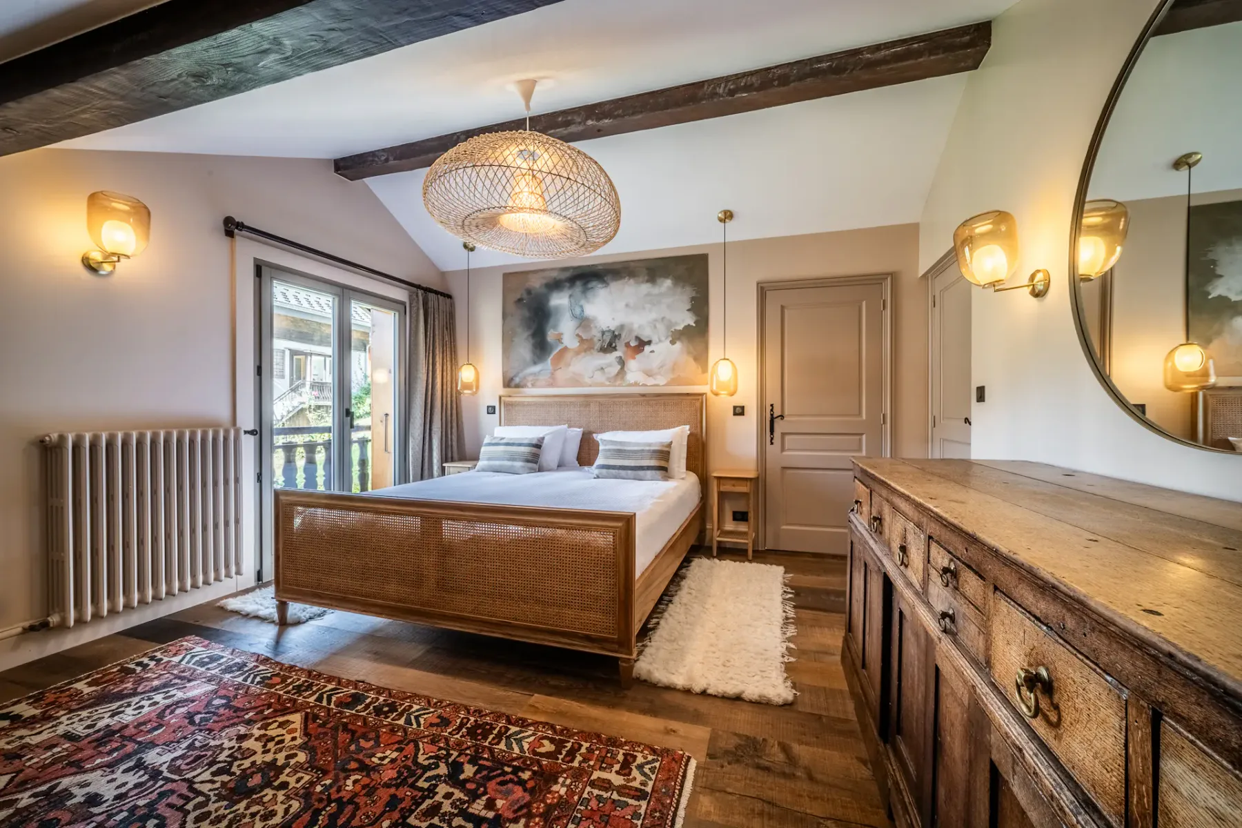 Un dormitorio con una cama de madera, mesitas de noche y una cómoda larga.