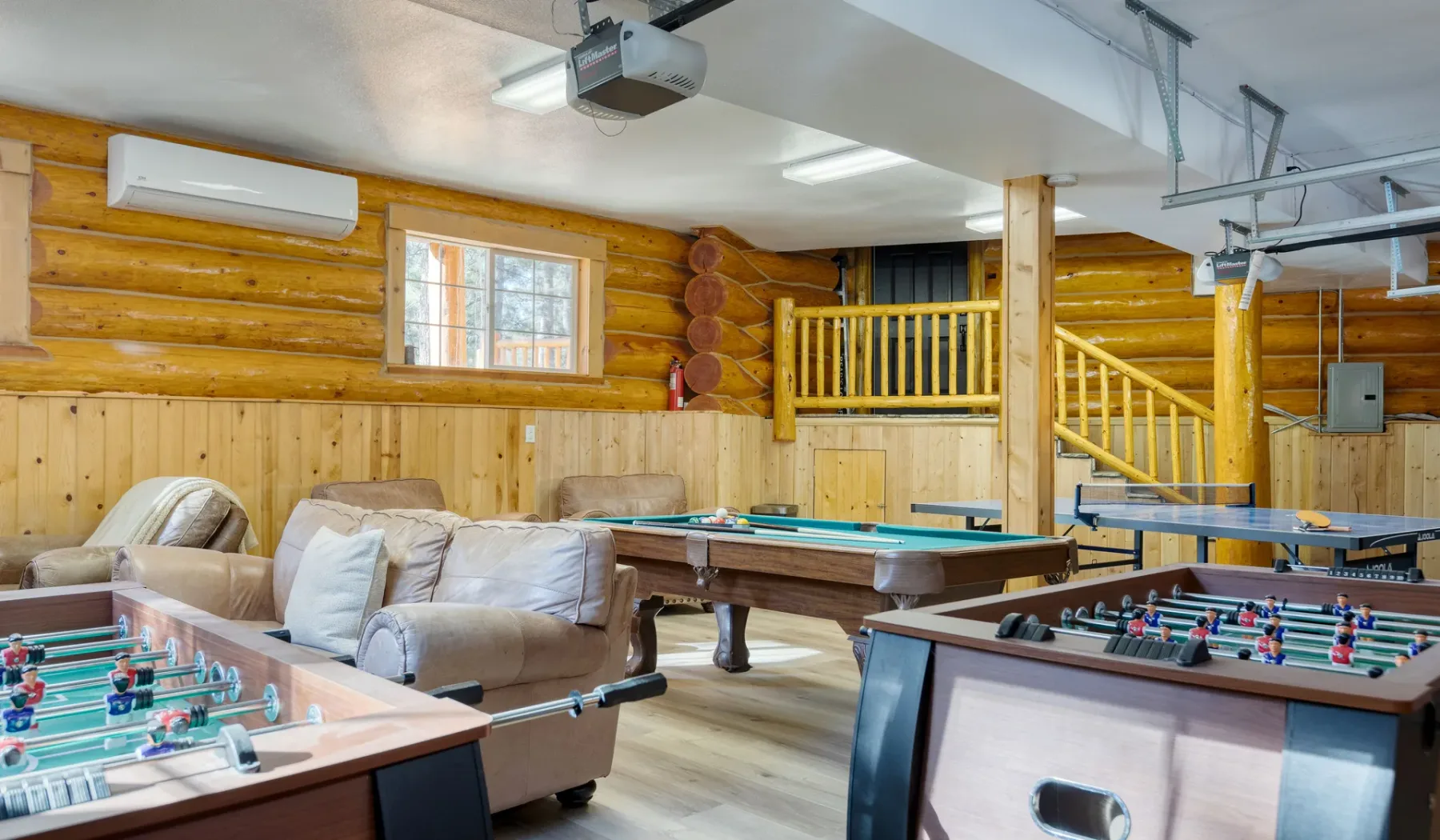 A recreation room with seating and several foosball tables.