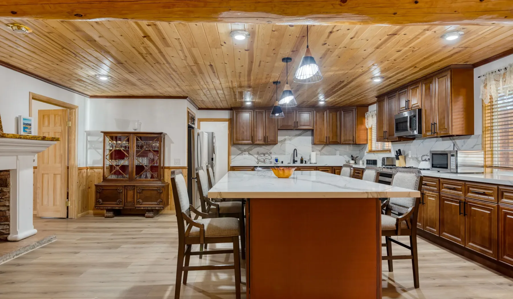 A spacious kitchen with a large central island and wooden cabinetry.