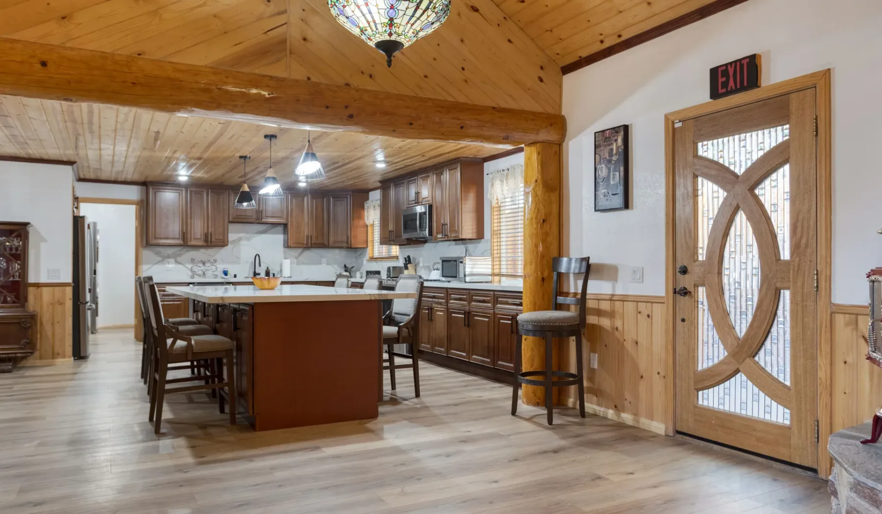 A spacious kitchen and dining area with wooden cabinetry and a large central island.