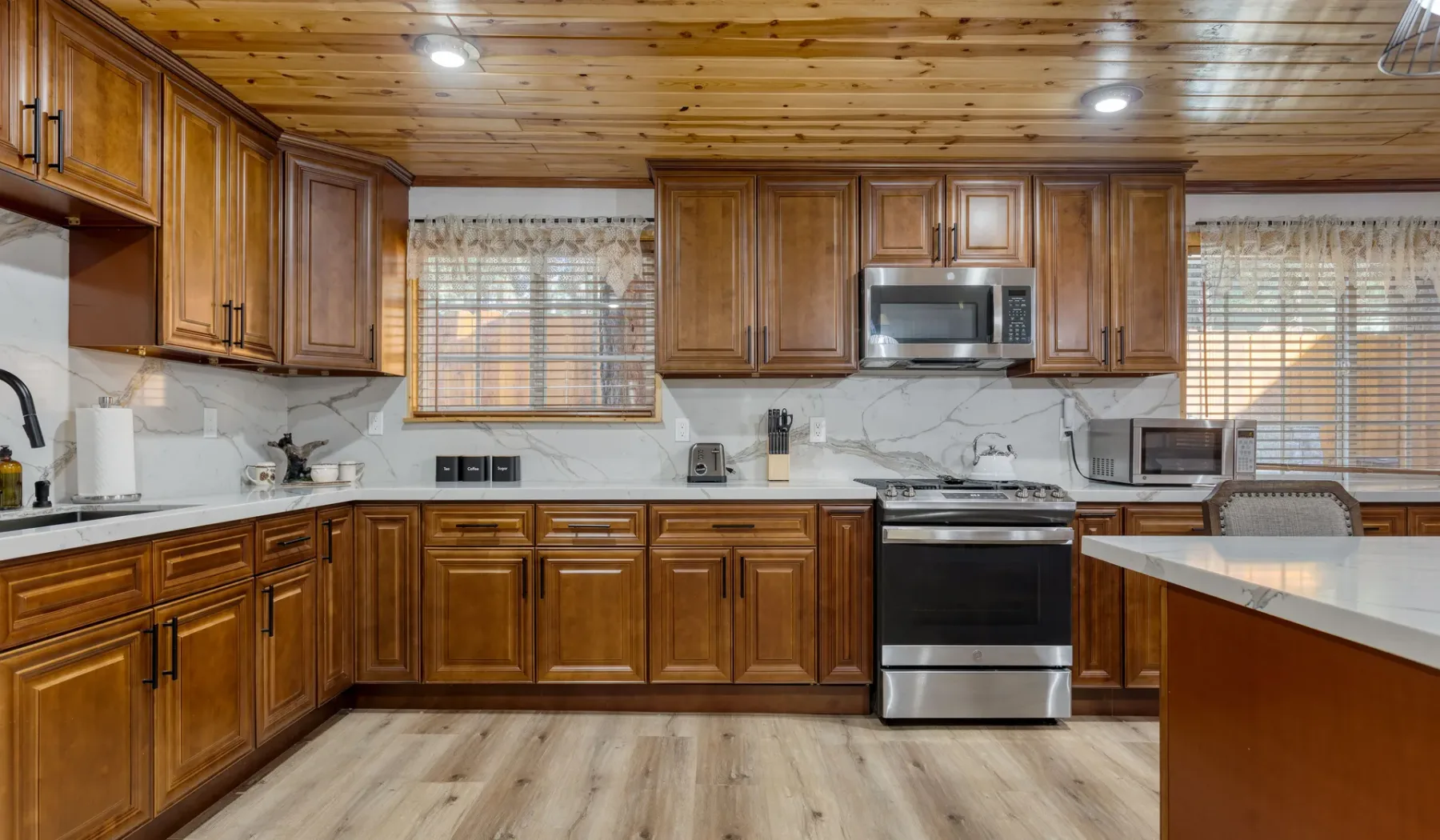 A spacious kitchen with wooden cabinets, stainless steel appliances, and a central island.