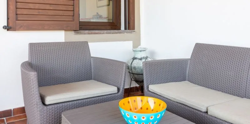 A seating area with gray woven furniture and a colorful bowl on the table.