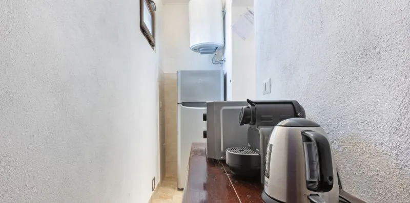 A narrow kitchenette counter holds a coffee maker and electric kettle.