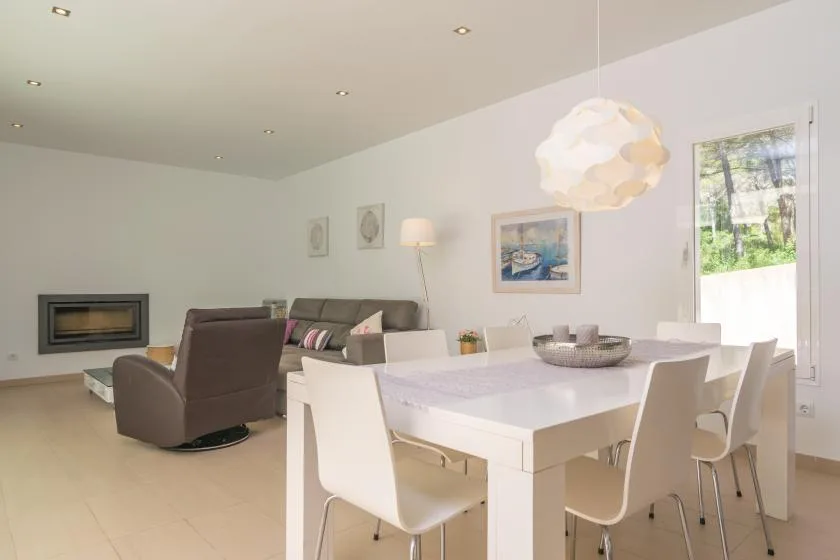 A bright living and dining room with a dining table beside the seating area.