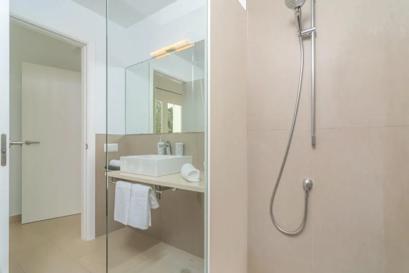 A bathroom with a wall-mounted sink and a shower.