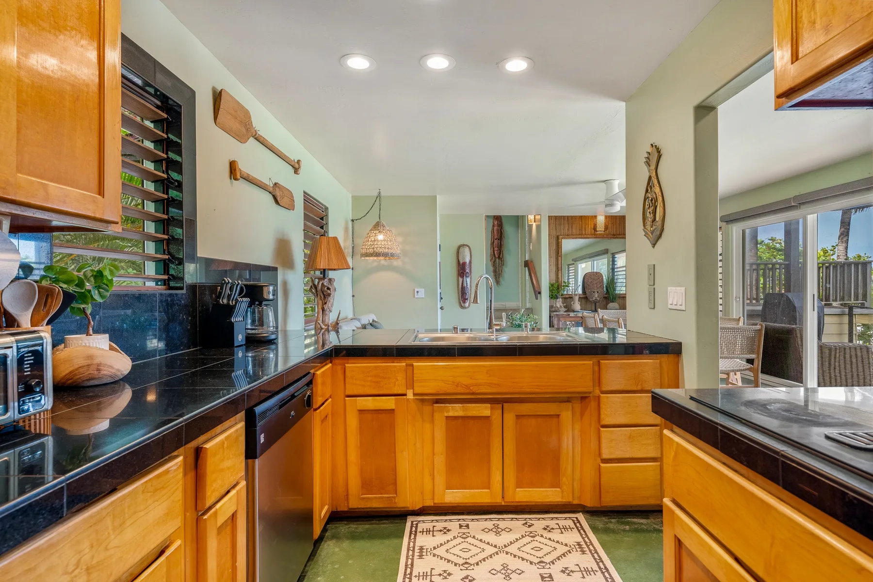 Una cocina luminosa con gabinetes de madera y encimeras oscuras.