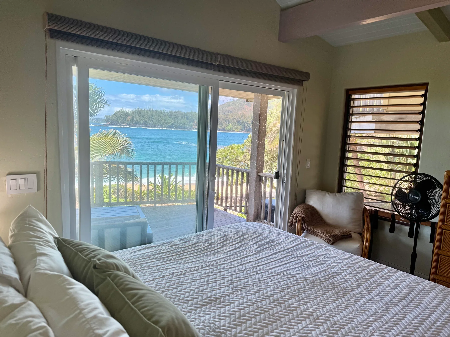 Un dormitorio con una cama junto a puertas corredizas de vidrio con vista al agua.