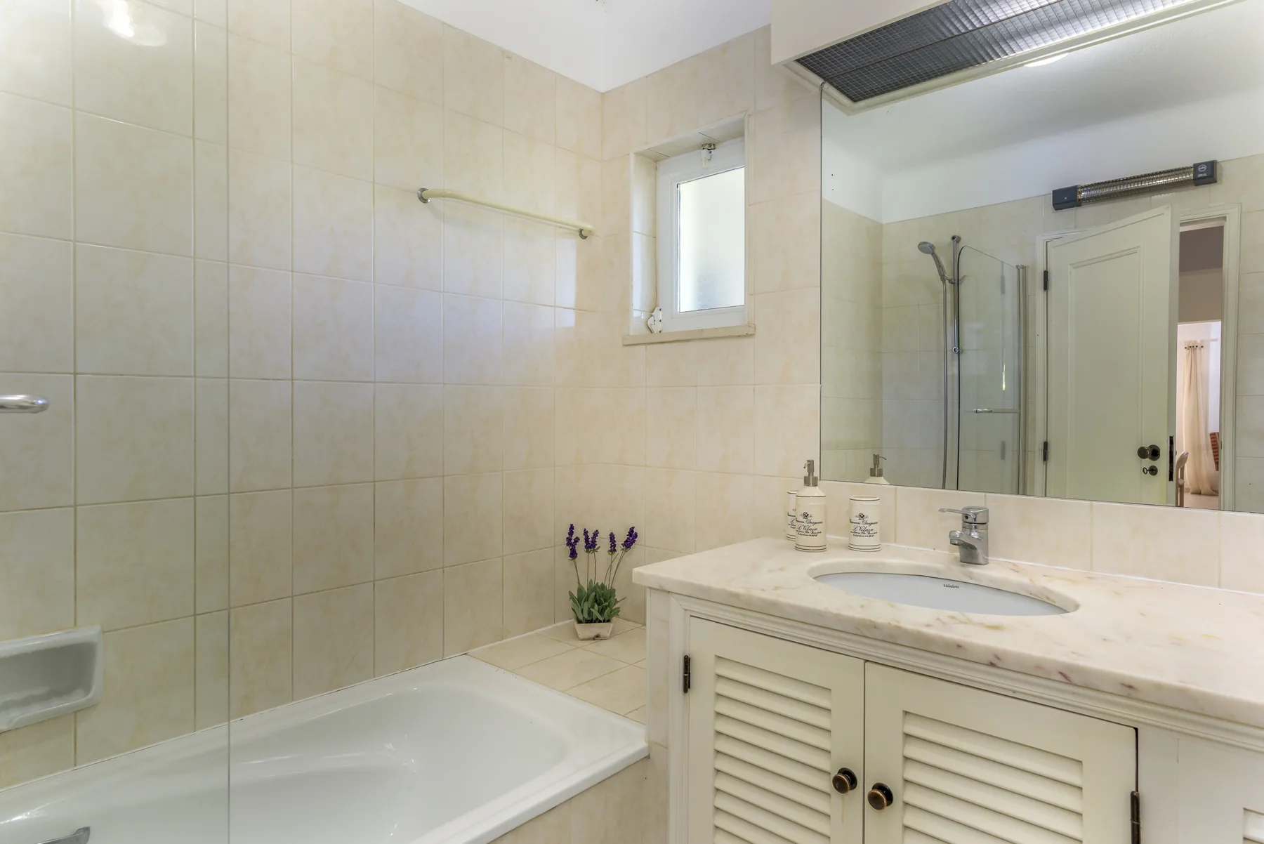 A tiled bathroom with a bathtub and vanity.