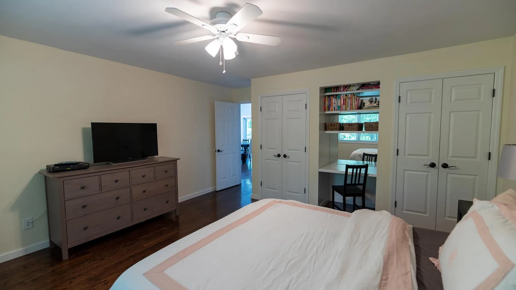 Un dormitorio con cama, cómoda y televisor.