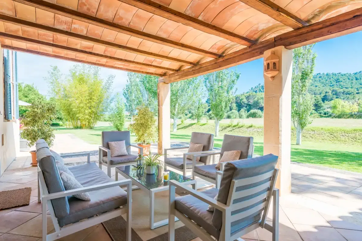 A covered outdoor seating area opens onto a garden.