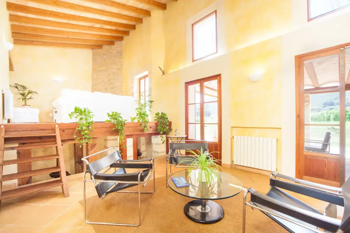A bright indoor seating area with wooden beams and large windows.