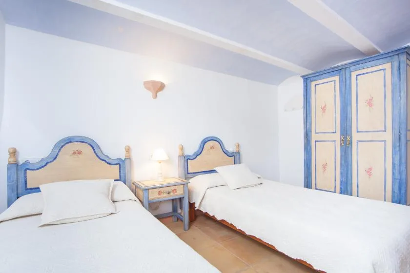 A bedroom with two beds and a small nightstand between them.