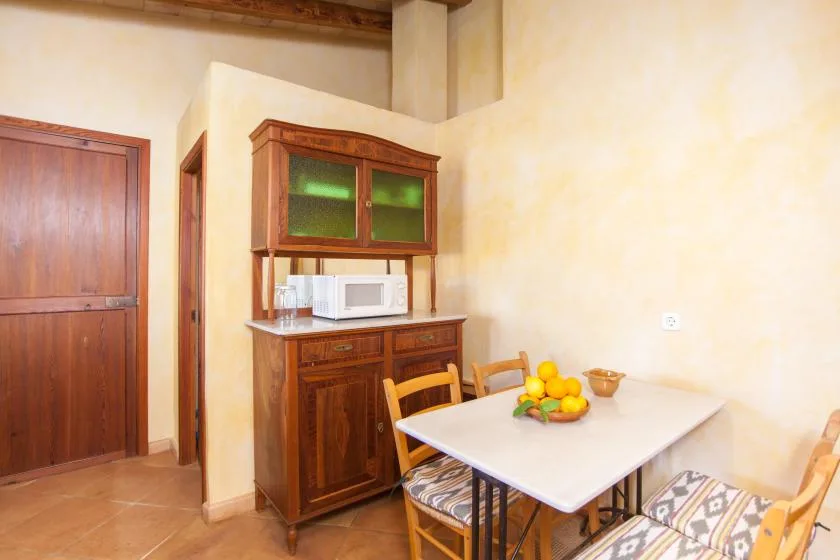 A dining area with a table, chairs, and a wooden cabinet.