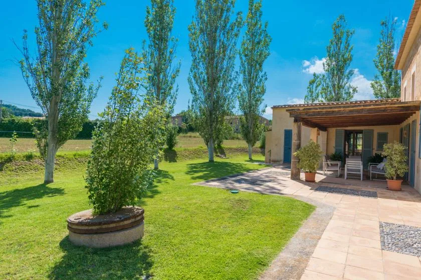A landscaped garden with a paved path leading to a covered patio.