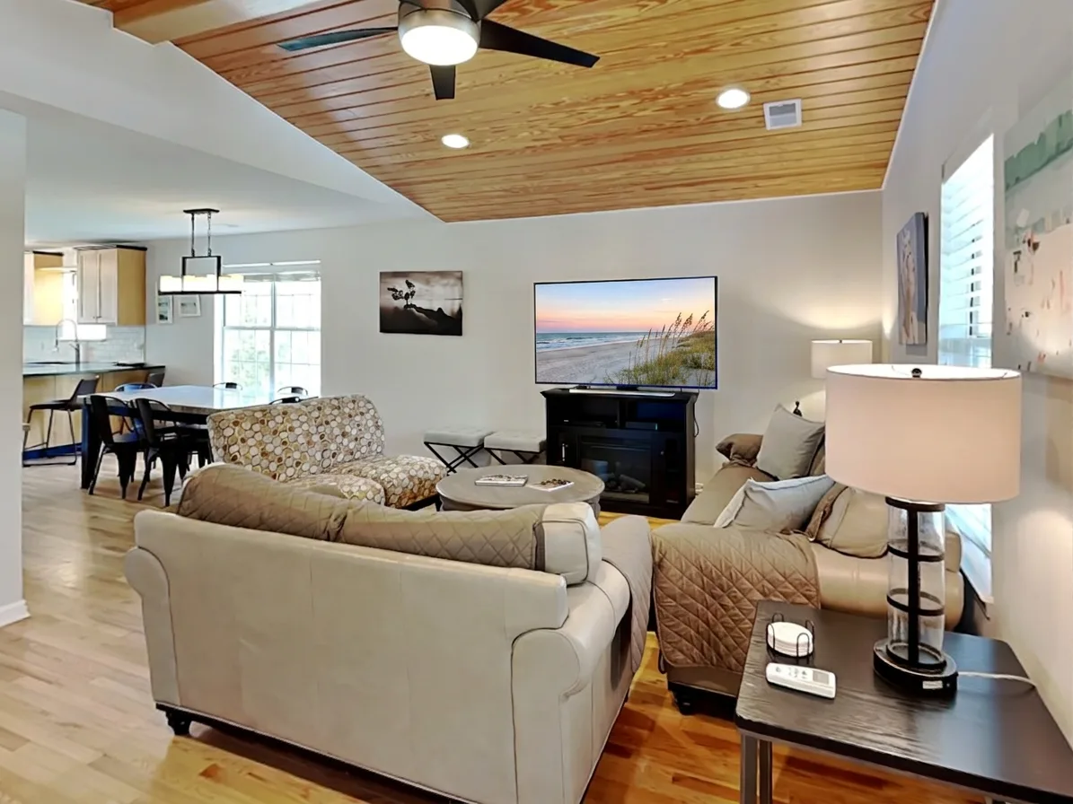 A living room with seating arranged around a coffee table and fireplace.