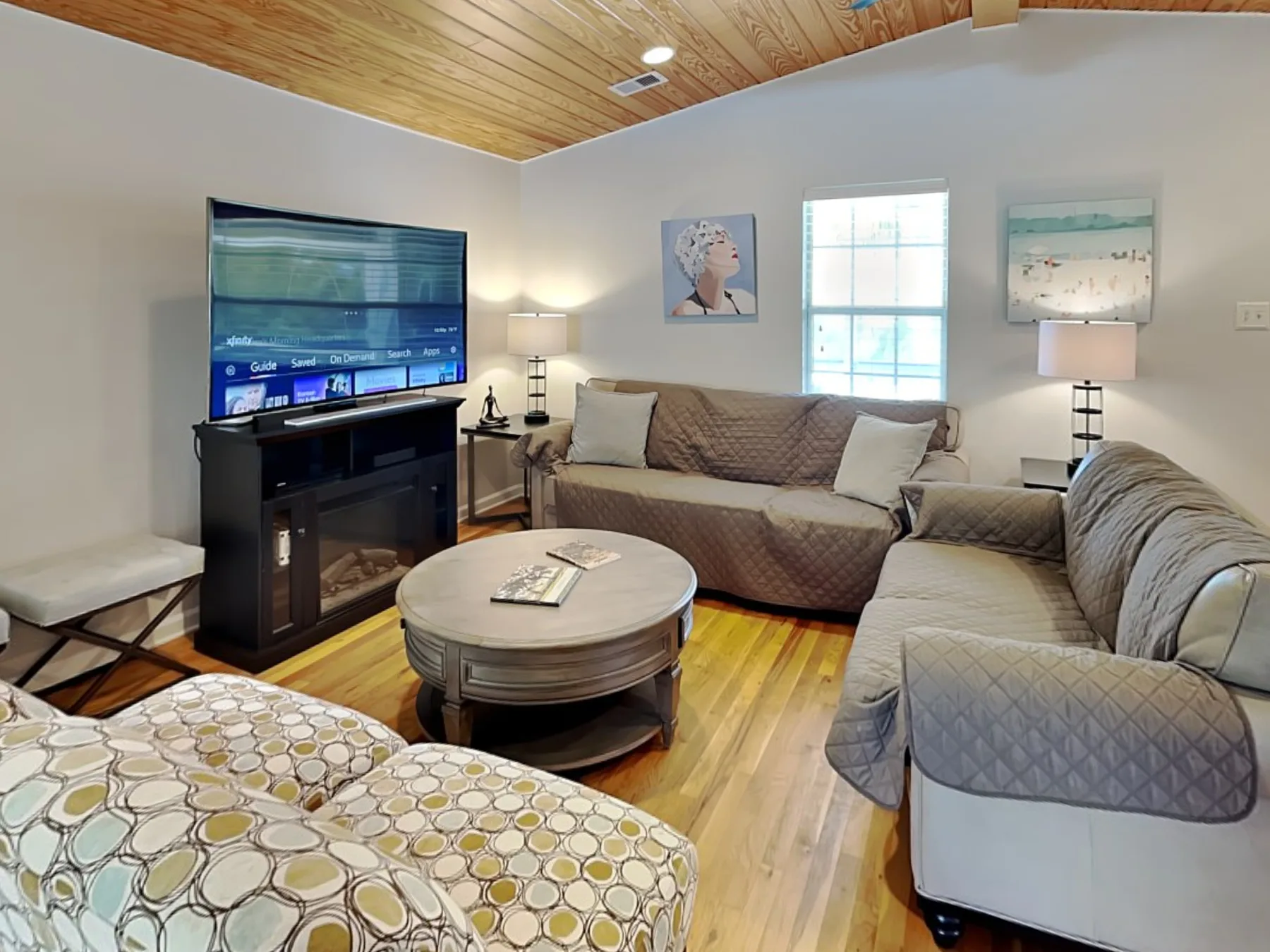 A living room with sofas, a television, and a round coffee table.