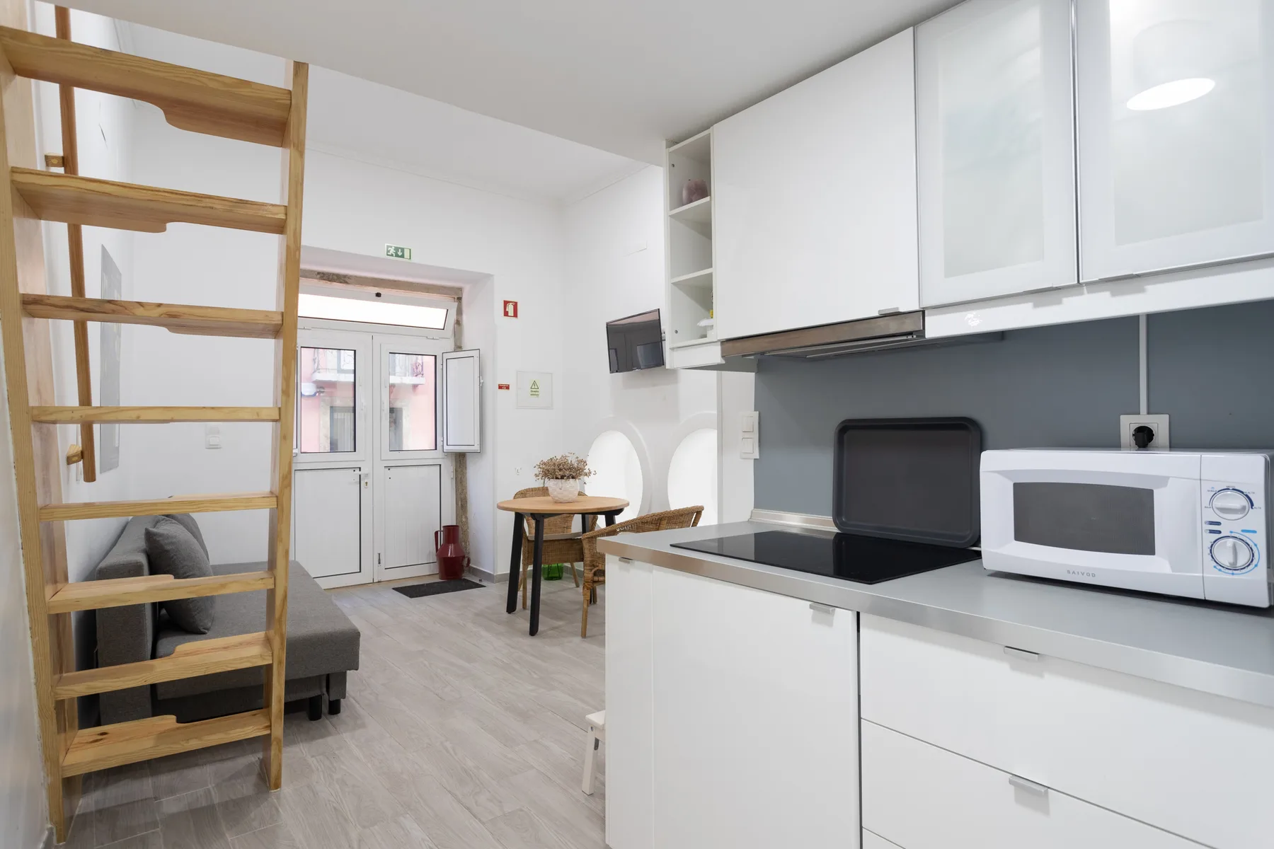 Una cocina compacta se abre a una pequeña zona de comedor y un espacio elevado para dormir.