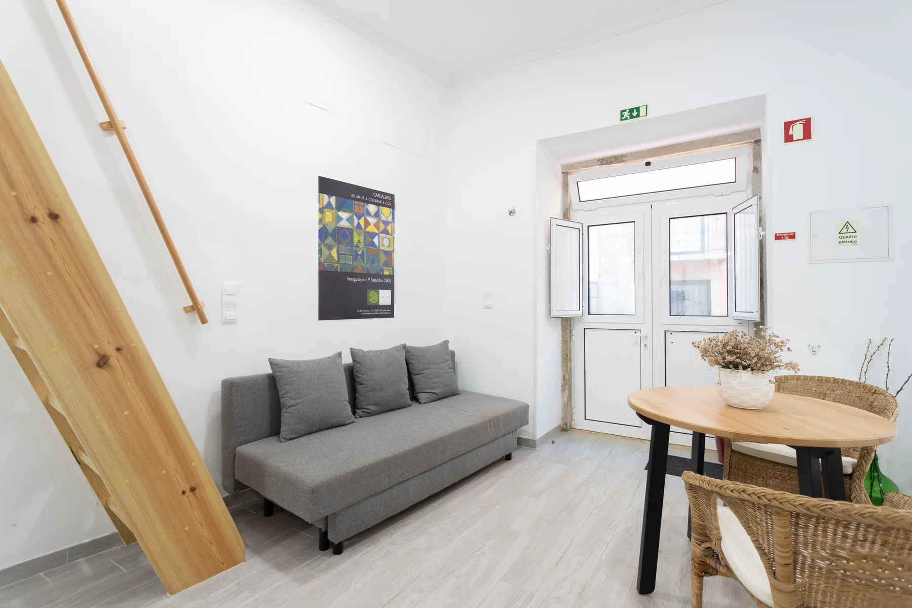 Una habitación luminosa con asientos, una mesa redonda y una puerta acristalada.