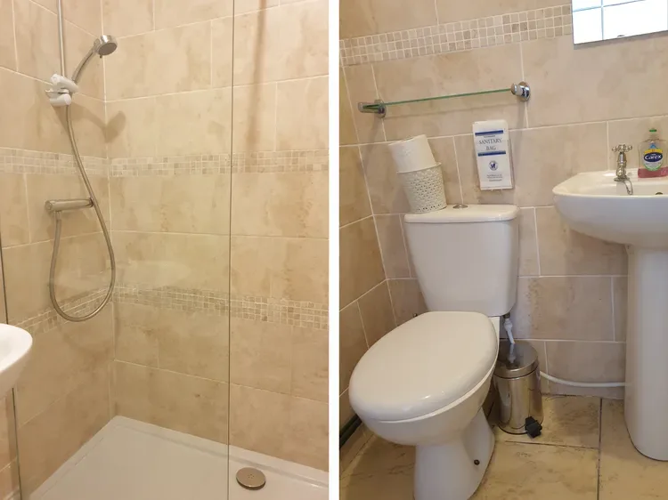 A tiled bathroom with a shower, toilet, and sink.